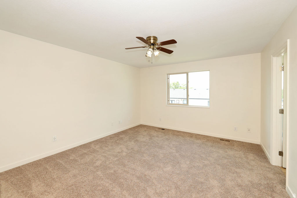 Spacious room featuring neutral carpeting and light-toned walls
