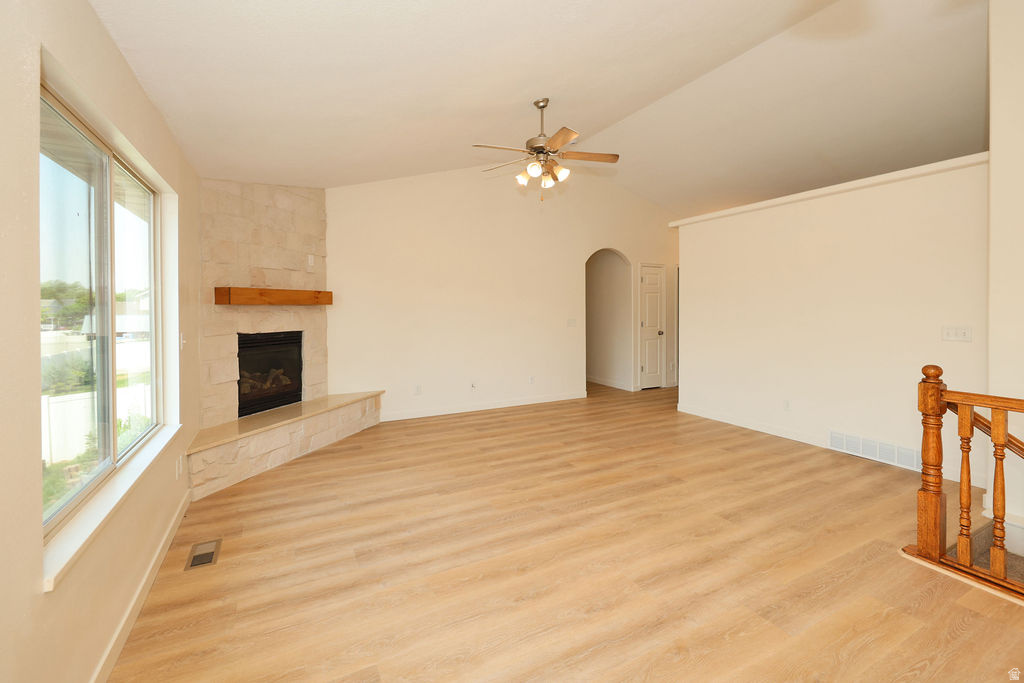 Spacious living area featuring light wood-finish flooring and vaulted ceilings