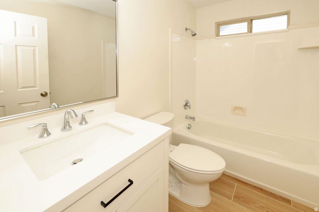 Bathroom featuring a white vanity with an integrated sink, chrome faucet, and rectangular mirror