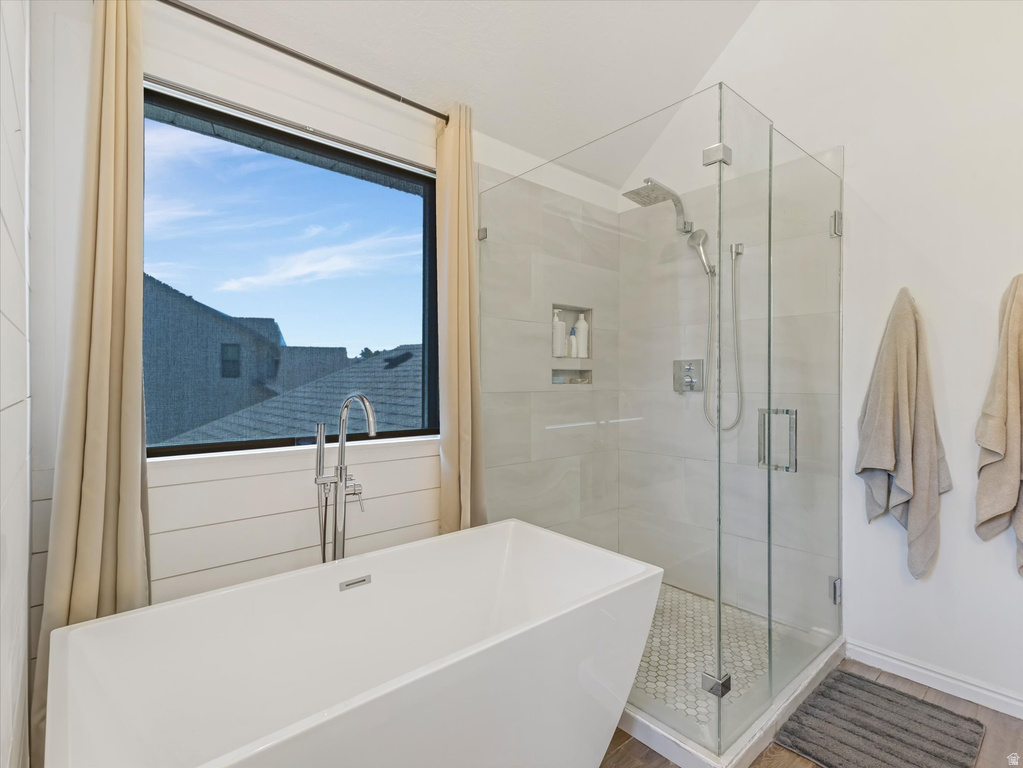 Contemporary bathroom featuring a freestanding soaking tub with a floor-mounted faucet, a glass-enclosed shower with tiled walls and a hex-tile floor, and a large picture window with shiplap wainscoting