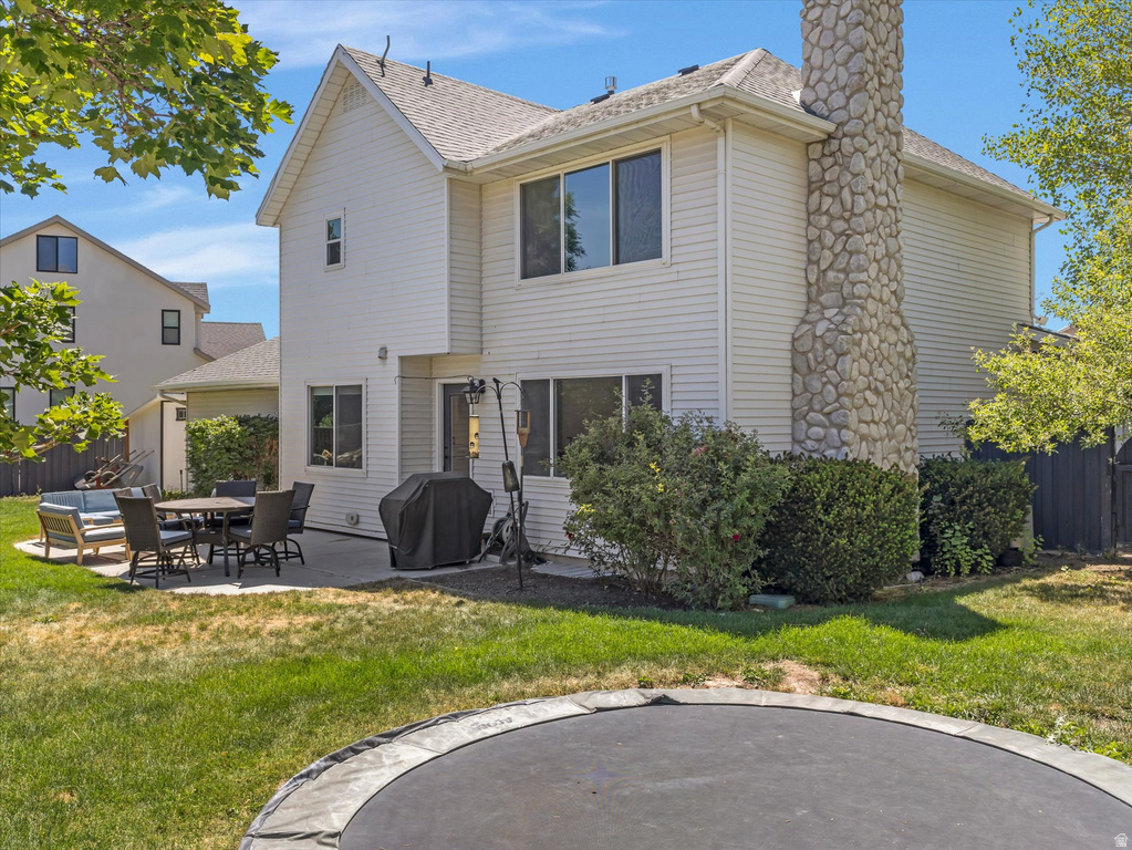 Rear exterior featuring white vinyl siding and a prominent stone chimney