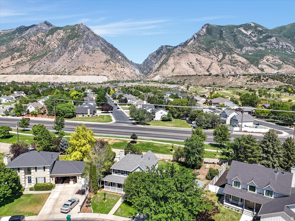 Expansive neighborhood setting featuring mature trees and mountain backdrops