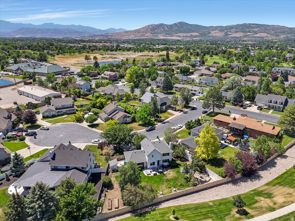 Residential neighborhood featuring mature trees, paved streets, and mountainous terrain in the background