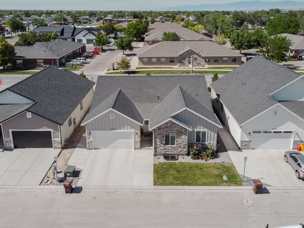 Single-story residence featuring a gray exterior with stone accents and a dual-pitch roofline