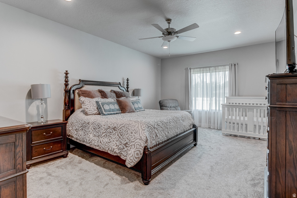 Spacious bedroom featuring light-toned carpeting, recessed lighting, and a ceiling fan