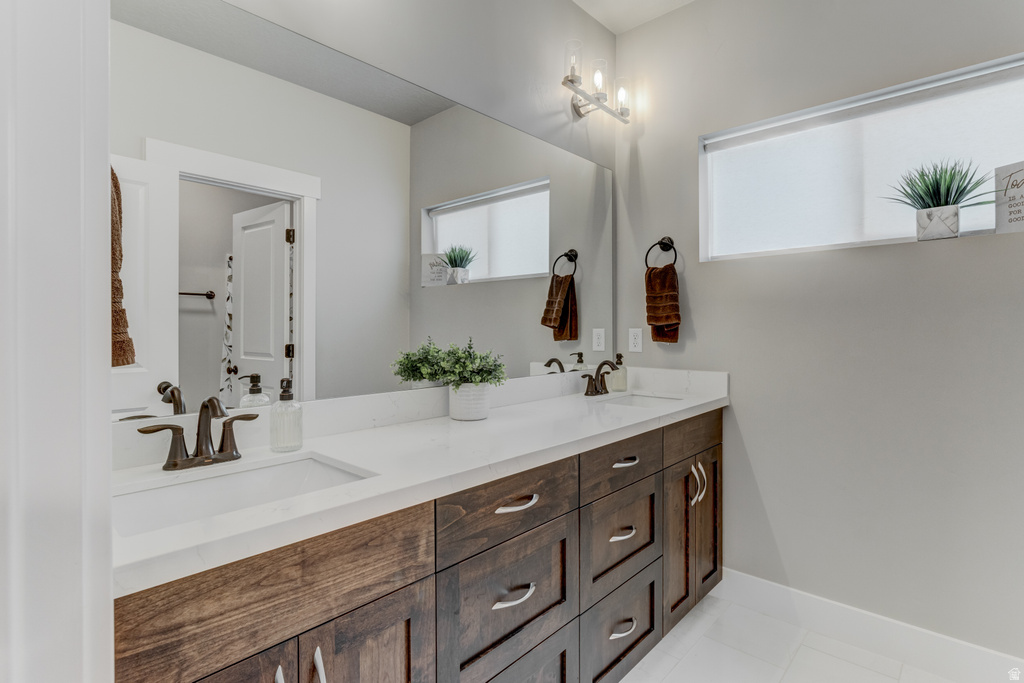 Dual vanity with dark wood-finish cabinetry, white countertops, and integrated rectangular sinks