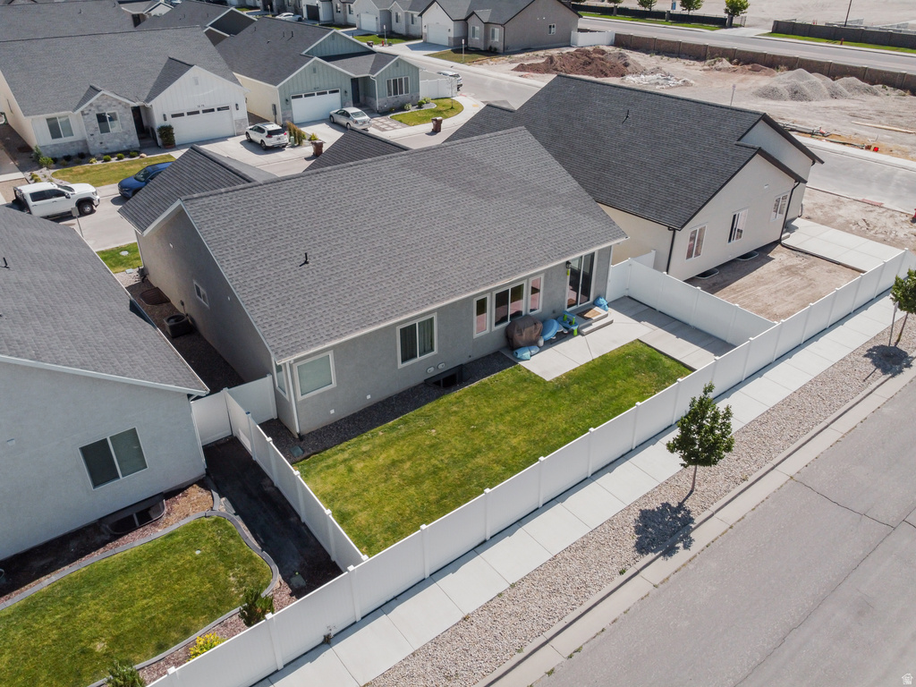 Rear exterior featuring a manicured lawn, concrete patio, and privacy fencing
