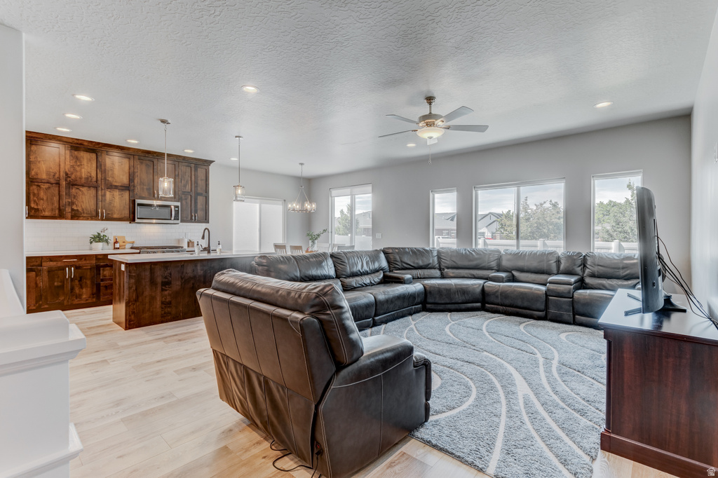 Open-concept living space featuring wood-finish flooring, recessed lighting, and a ceiling fan