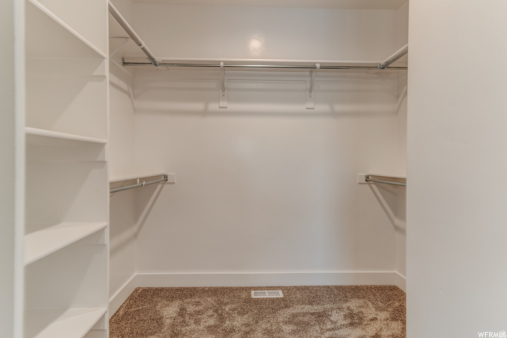 Built-in shelving, multiple hanging rods, and textured carpeting
