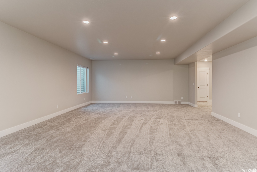 Spacious carpeted room featuring recessed lighting, a single window, and neutral-toned walls