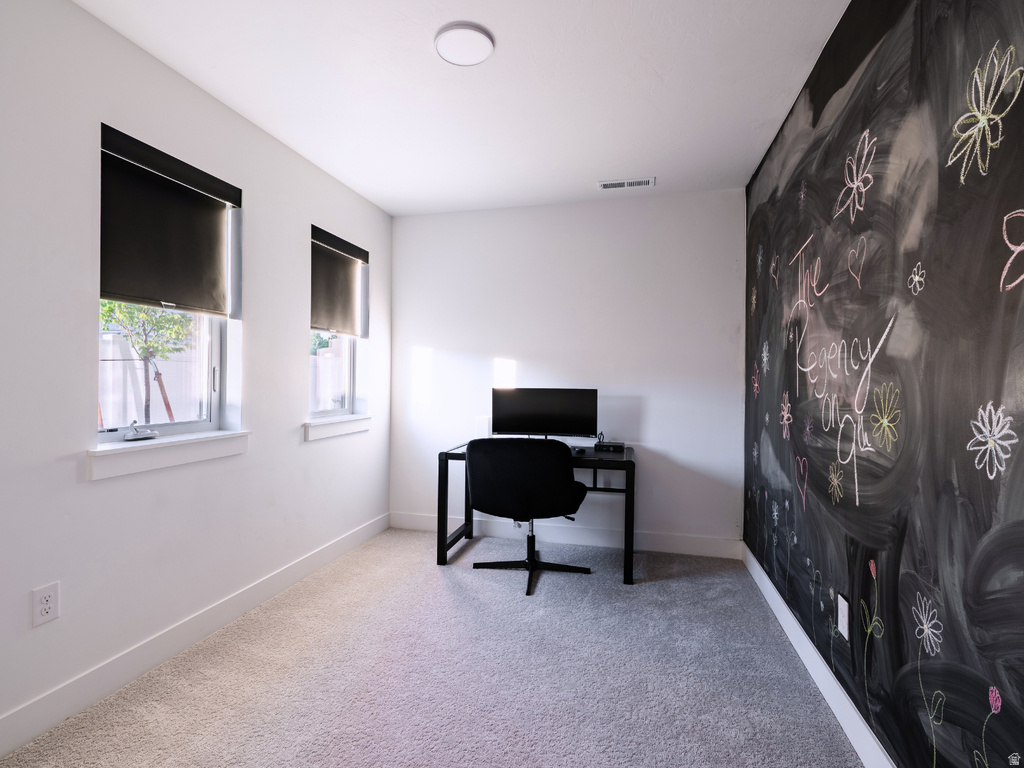 Light-filled room featuring two windows with blackout roller shades, a chalkboard accent wall, plush carpeting, and recessed ceiling lighting
