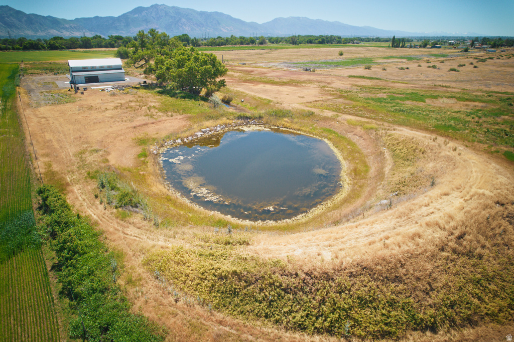 Expansive acreage featuring a private pond, large detached barn, mature trees, and mountainous backdrop