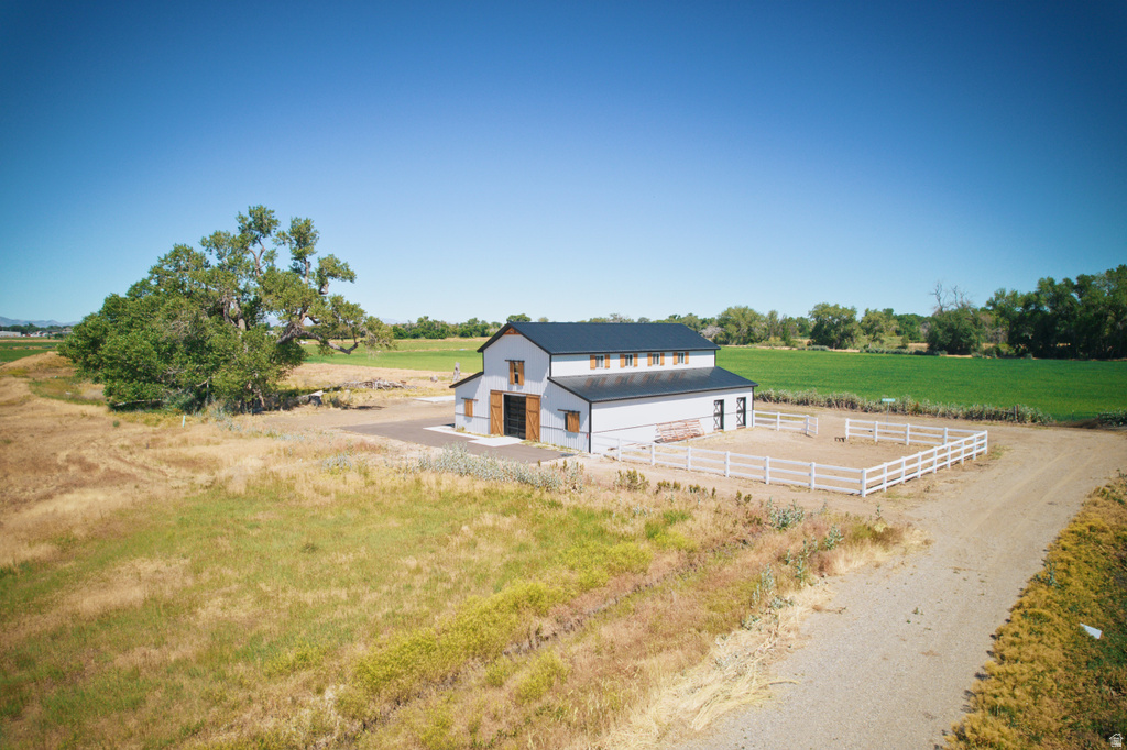 Modern barn structure featuring a dark roof, light gray siding, and natural wood barn doors
