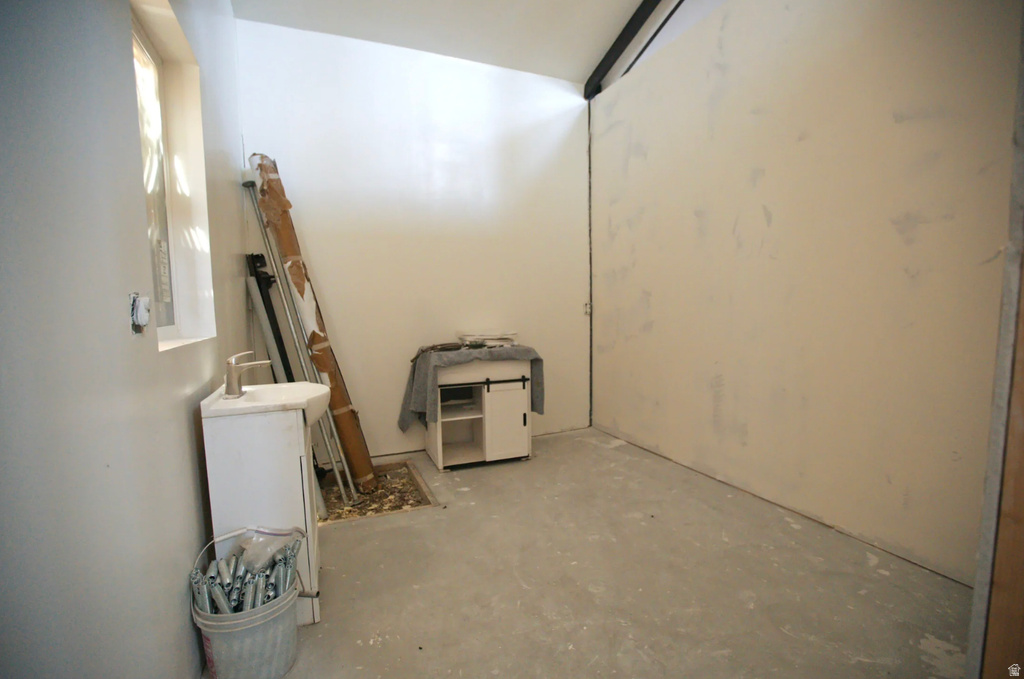 Unfinished interior space featuring light-colored walls and a concrete floor
