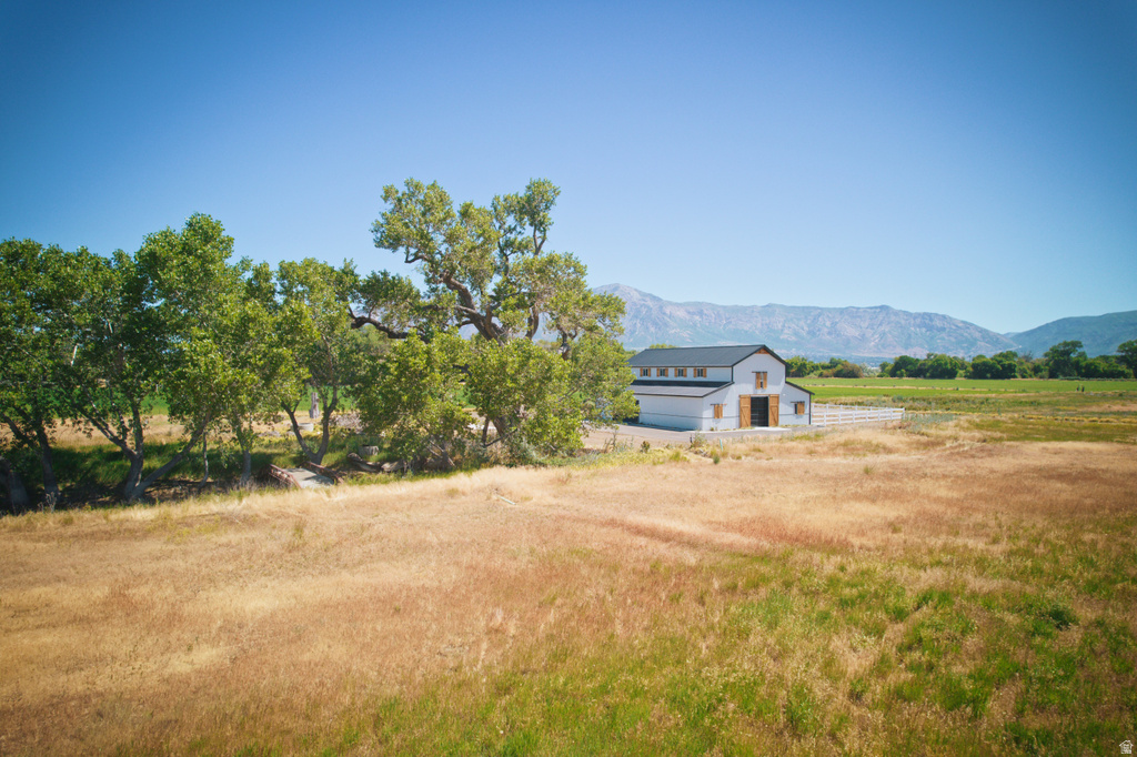 Modern white barn-style structure featuring a dark roof, exposed wood doors, and clear-story windows