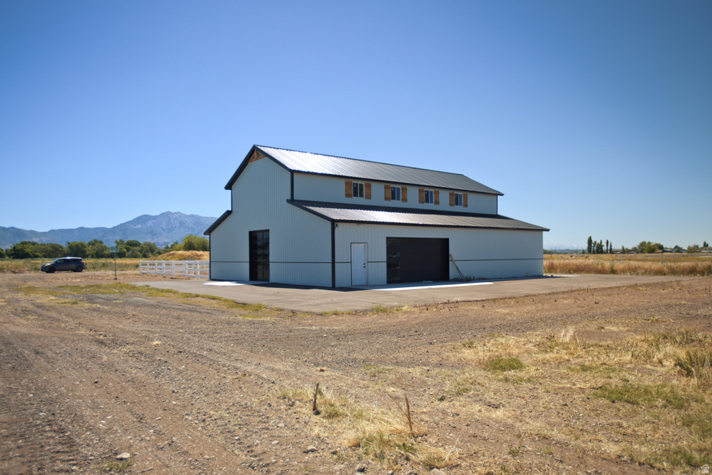 Two-story pole barn structure with a metal roof and light-colored siding