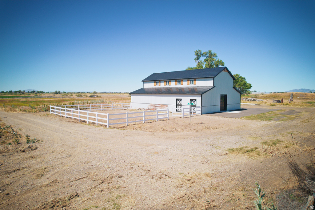Two-story barn structure featuring white siding, a dark roof, and wood-finish shutters