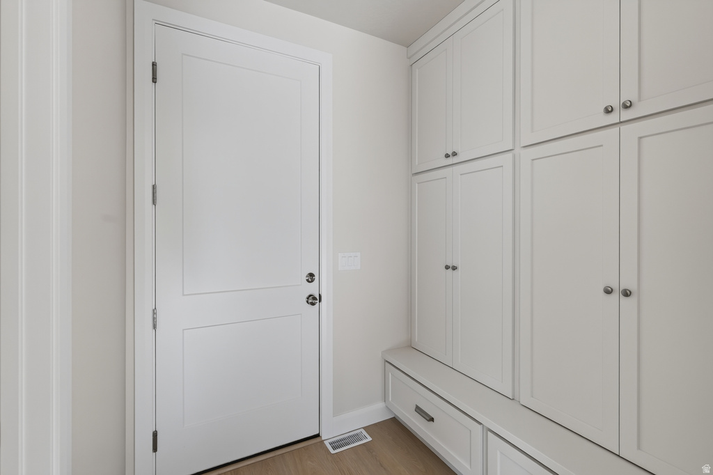 Built-in cabinetry with panel detailing, integrated bench seating, and wood-finish flooring
