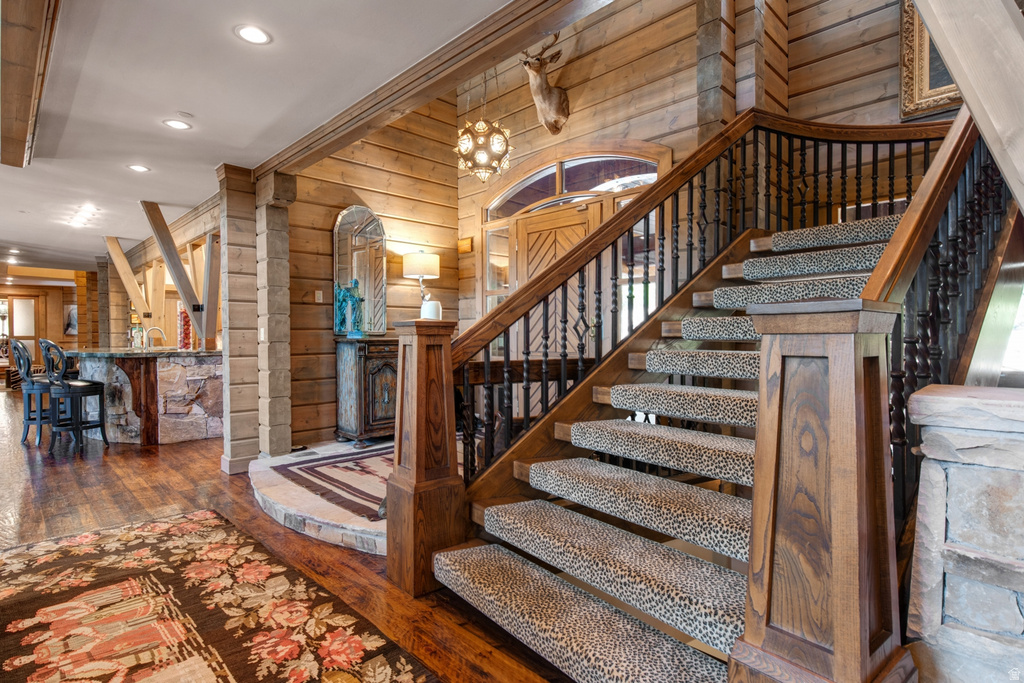 Grand staircase featuring wood treads, dark wood newel posts, and wrought iron balusters