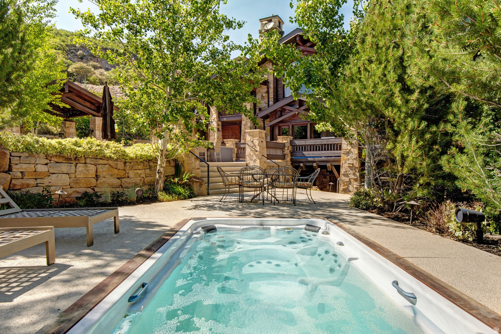 Outdoor spa tub with surrounding aggregate concrete patio