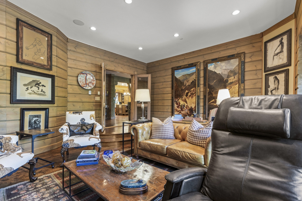 Living area featuring horizontal wood paneling, recessed lighting, and wood-finish flooring