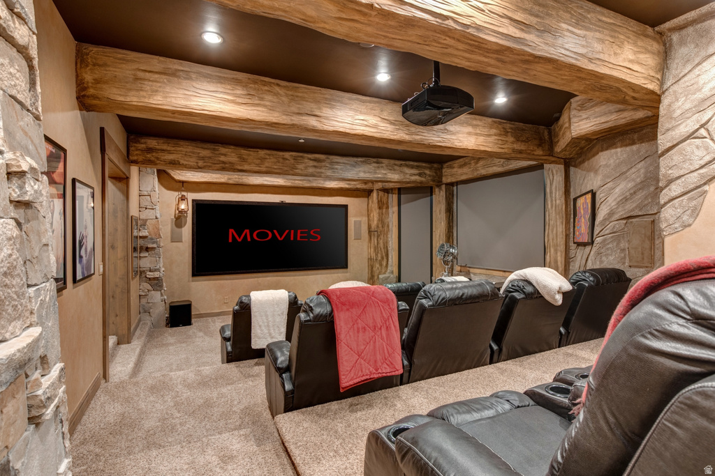 Dedicated home cinema featuring a large projection screen, integrated projector, and tiered seating