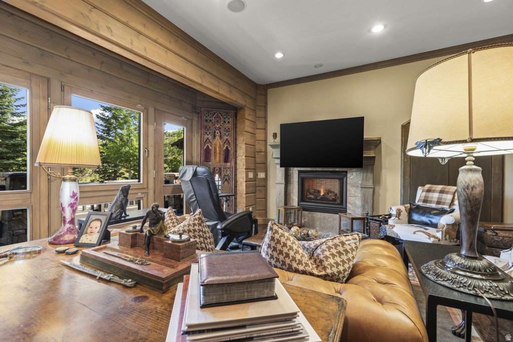 Wood-paneled room featuring large windows, a built-in fireplace with a stone surround, and recessed ceiling lighting