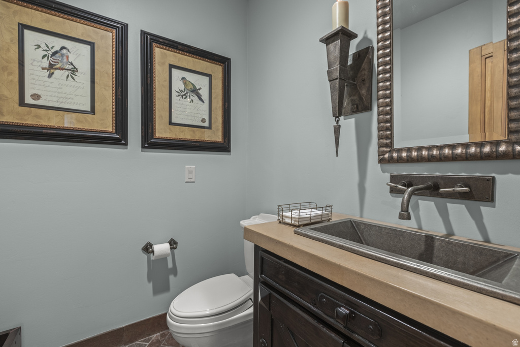 Powder room featuring a rectangular basin sink, wall-mounted faucet, and a wall sconce