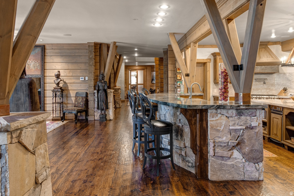 Spacious kitchen island featuring a stone-clad base, integrated sink, and seating for multiple guests