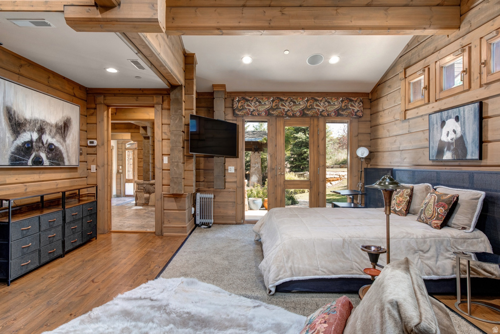 Expansive room featuring wood-finish walls and ceiling beams, wood-finish flooring, and recessed lighting