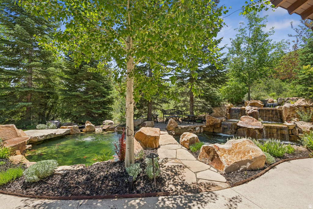 Expansive outdoor water feature showcasing multiple cascading waterfalls, a tranquil pond, and natural stone landscaping
