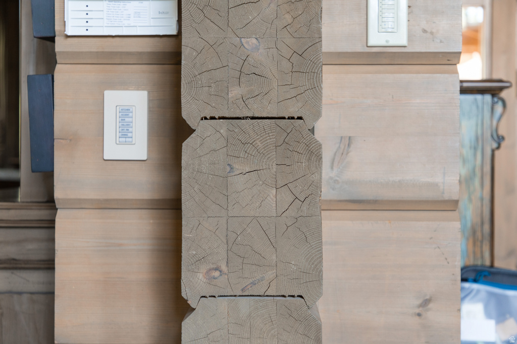 Stacked timber beam construction with prominent natural wood grain and visible checks
