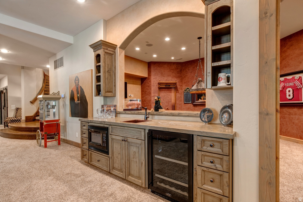 Custom wet bar featuring a built-in microwave, beverage cooler, and integrated sink