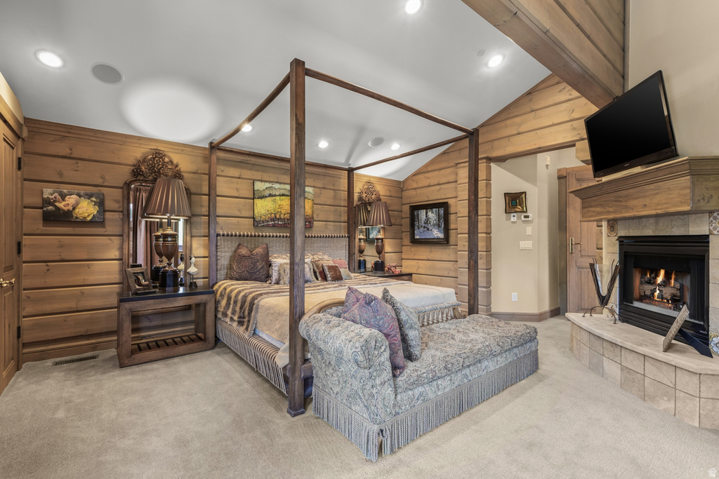 Vaulted ceiling with exposed wood beams, wood-paneled walls, a built-in fireplace with tile surround, a wood mantel, and recessed lighting