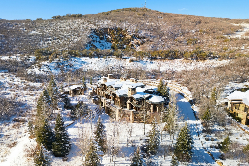 Multi-level residence featuring a stone and wood exterior with multiple balconies and a snow-covered roof