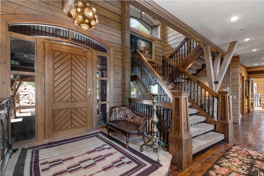 Grand entryway featuring a custom wood door with chevron paneling, flanking sidelights, and an arched transom window