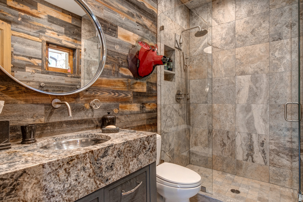 Vanity featuring a polished granite countertop with an integrated sink and wall-mounted faucet, complemented by a round mirror