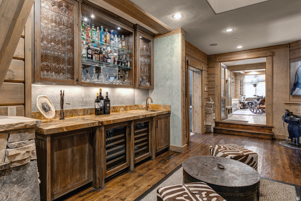 Custom bar area featuring under-cabinet lighting, glass shelving, and two built-in beverage refrigerators