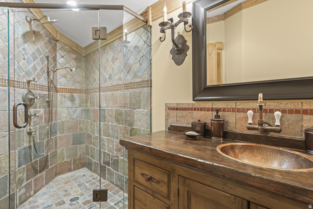 Shower with glass enclosure, multi-tone tile surround, and dual showerheads