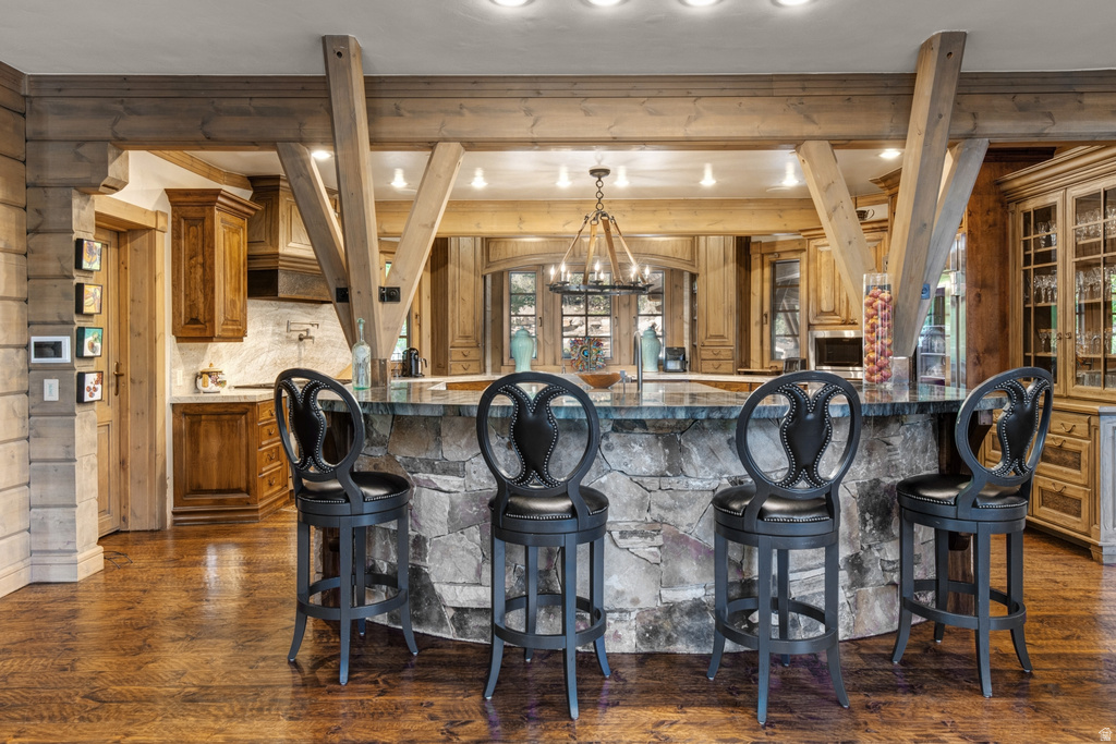 Stone-clad kitchen island with a dark countertop and integrated breakfast bar