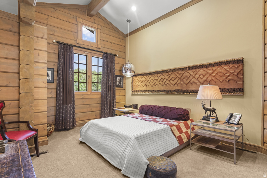 Vaulted ceiling with wood beams, light wood paneling, and a large window with grid panes