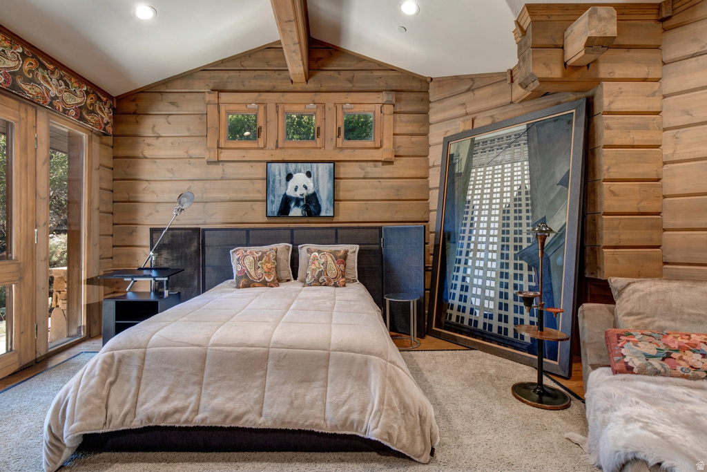 Exposed wood walls and vaulted ceilings characterize this room, featuring a built-in upholstered headboard