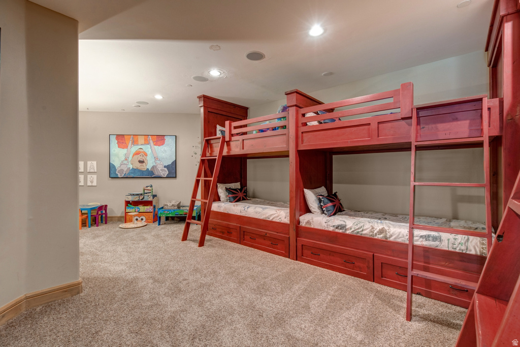 Carpeted room featuring two built-in bunk beds with integrated storage drawers