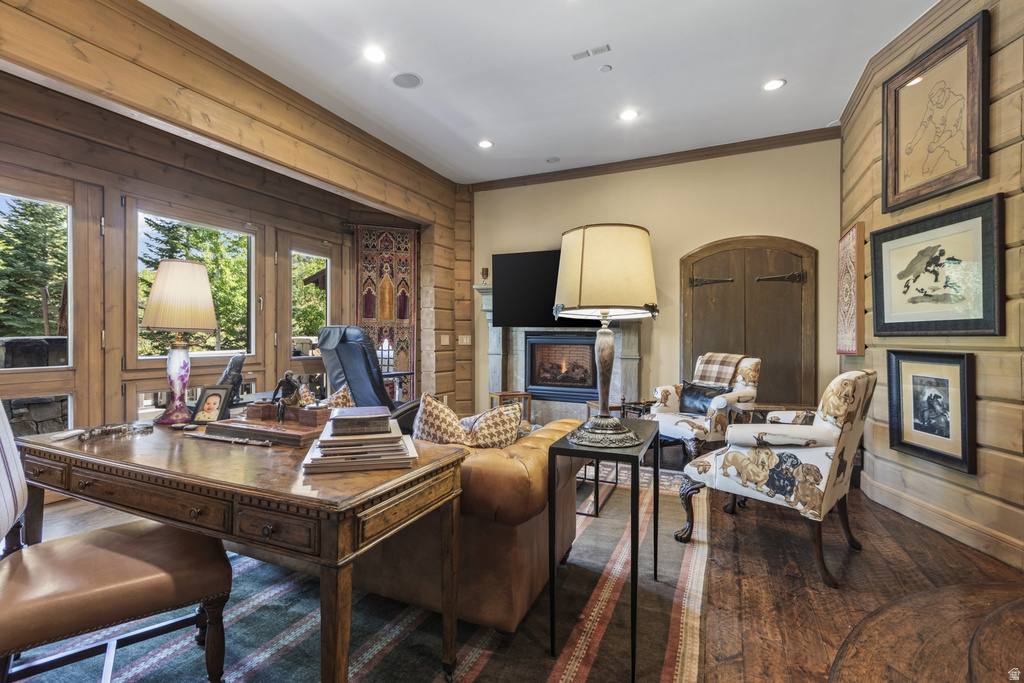 Spacious room featuring wood-finish flooring, a built-in fireplace, and expansive windows