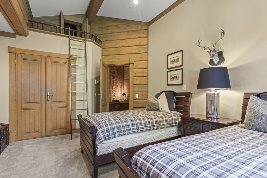 Interior room featuring wood-finish ceiling beams and a loft area accessed by a ladder