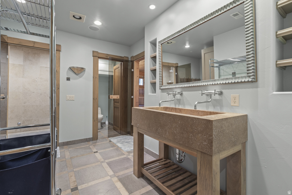 Dual wall-mounted faucets over a rectangular stone vessel sink with an open wood base