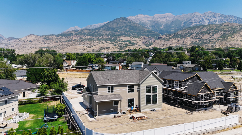 Modern home featuring a striking two-tone exterior with light and dark siding, multiple gabled rooflines, and expansive hardscaped patio area