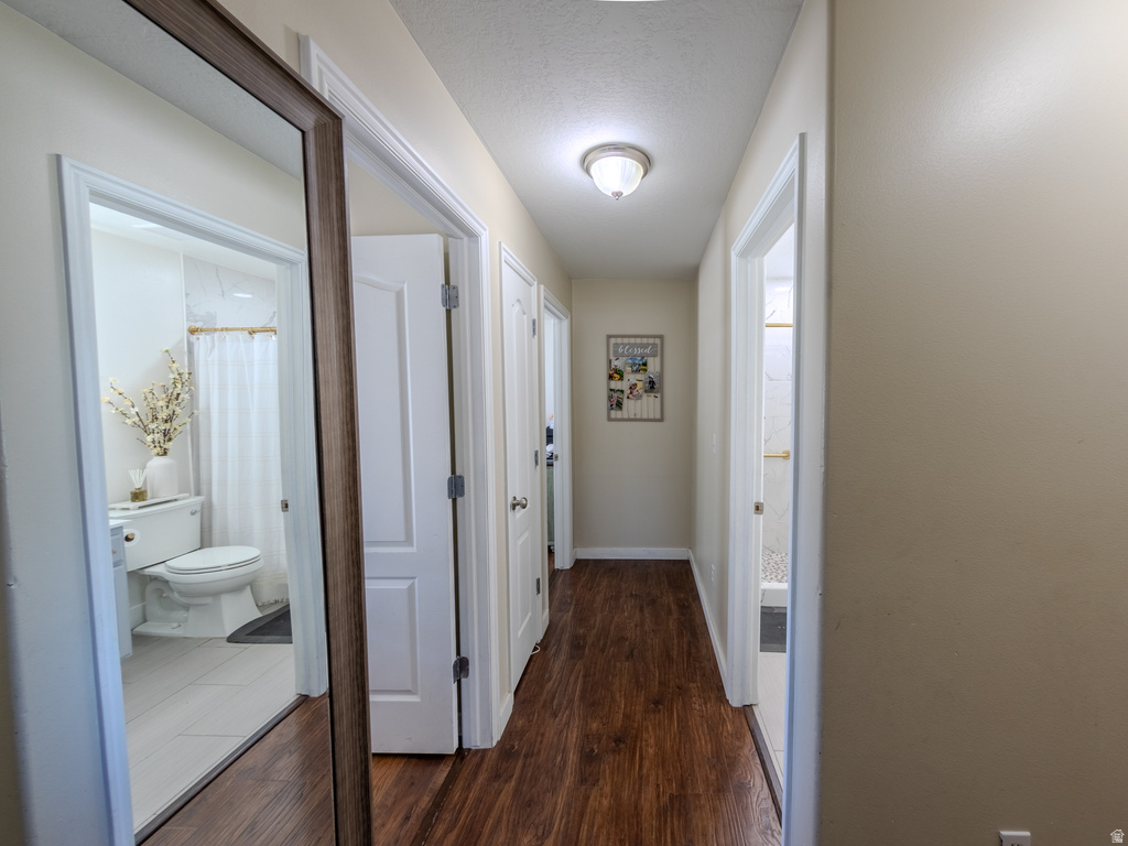 Hallway featuring wood-finish flooring, light-toned walls, and recessed lighting