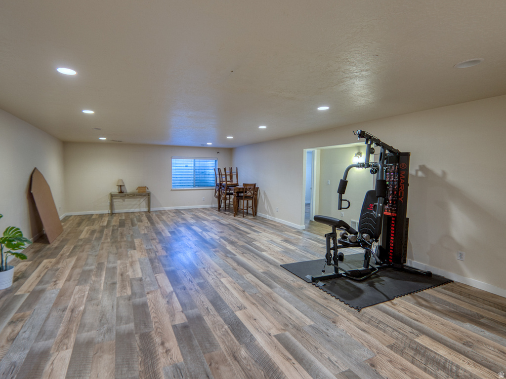 Spacious open room featuring wood-finish flooring, recessed lighting, and light-toned walls