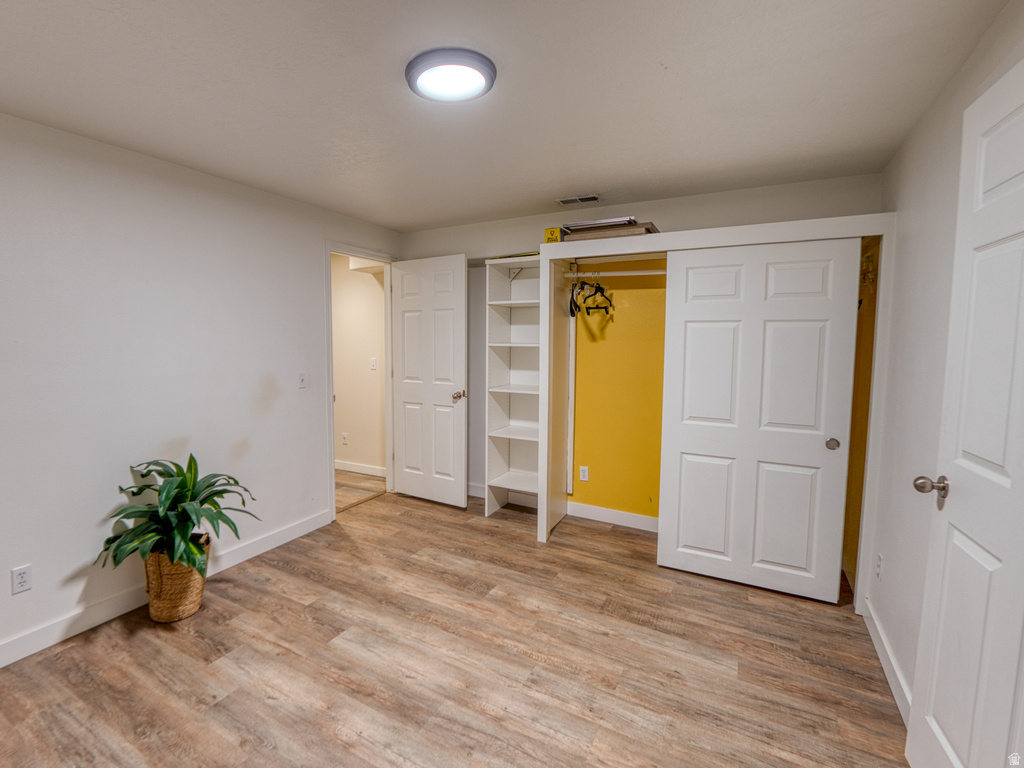 Interior room featuring wood-finish flooring, white baseboards, and a flush-mount ceiling light